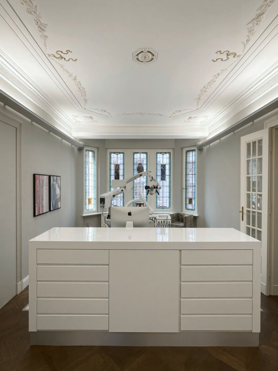 Salle de soins avec vitraux, microscope dentaire et plafond en stuc